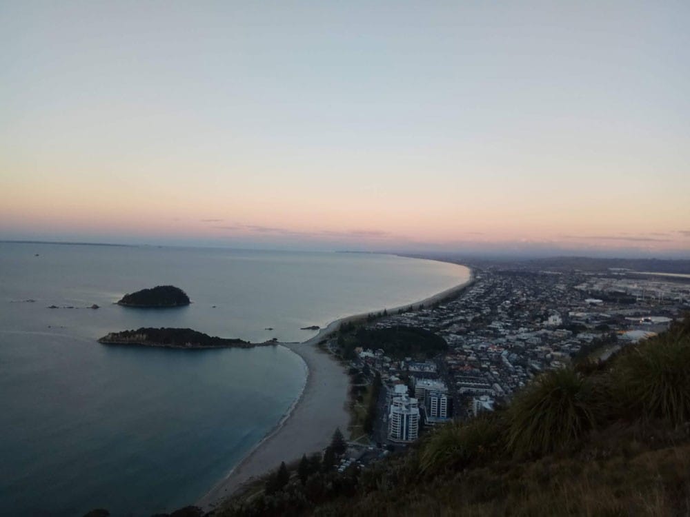Ciudades Nueva Zelanda fotografía de la puesta de sol de una ciudad de Nueva Zelanda con el mar y los edificios de fondo